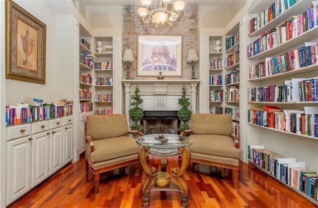 350 Emerald Forest Blvd Unit 17103, Covington, LA 70433 - living area featuring a chandelier, wood finished floors, a fireplace, bookshelves, and built in shelves