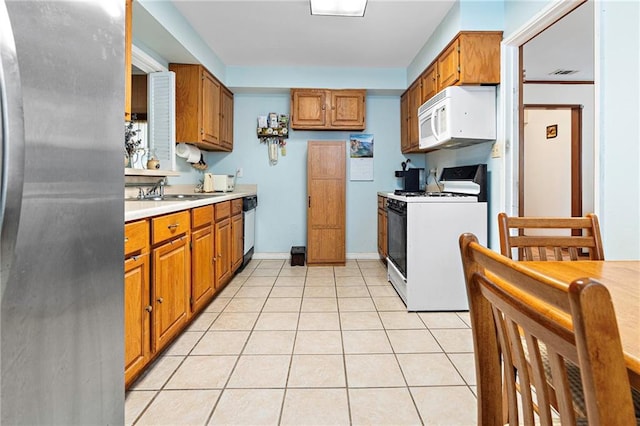3513 Haring Rd, Metairie, LA 70006 - kitchen featuring stainless steel appliances, brown cabinetry, light countertops, and light tile patterned floors
