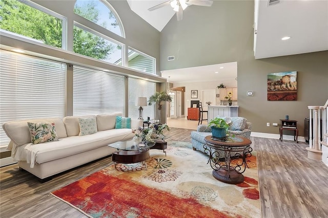 1424 Woodmere Dr, Mandeville, LA 70471 - living area featuring wood finished floors, baseboards, high vaulted ceiling, ceiling fan, and recessed lighting