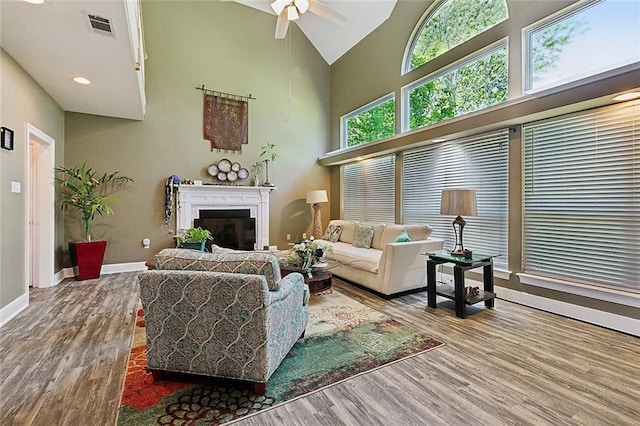 1424 Woodmere Dr, Mandeville, LA 70471 - living room featuring wood finished floors, ceiling fan, baseboards, high vaulted ceiling, and a fireplace