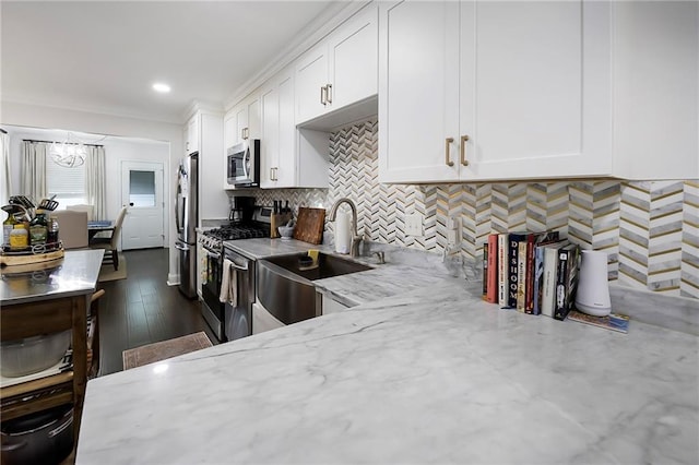 6208 Lafreniere St, Metairie, LA 70003 - kitchen with stainless steel appliances, a sink, white cabinets, backsplash, and recessed lighting