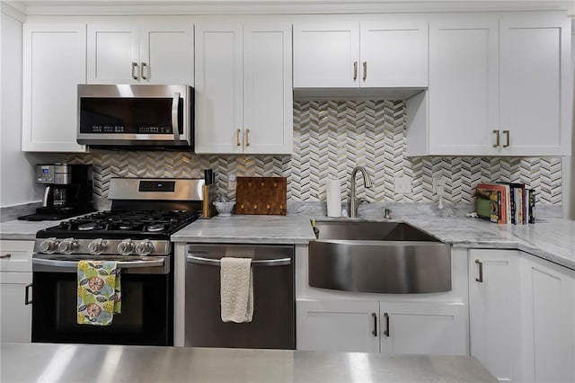 6208 Lafreniere St, Metairie, LA 70003 - kitchen with stainless steel appliances, a sink, white cabinetry, and decorative backsplash