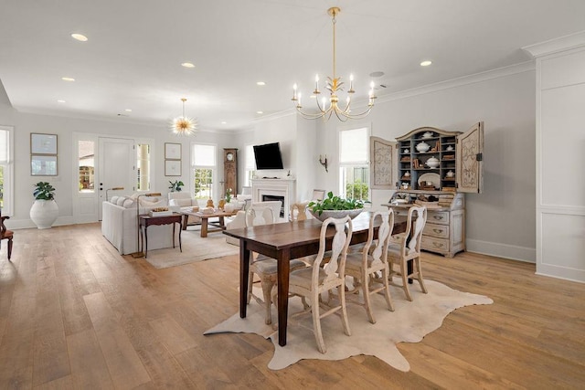 65 Hummingbird Rd, Covington, LA 70433 - dining area featuring a fireplace, a chandelier, recessed lighting, light wood-style floors, and crown molding