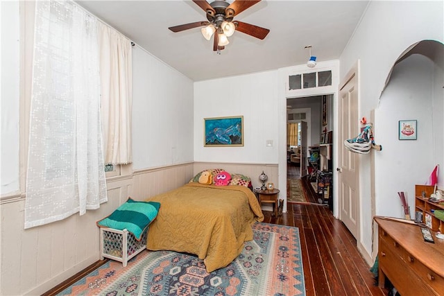 262830 N Rampart St, New Orleans, LA 70117 - bedroom featuring hardwood / wood-style floors, arched walkways, a wainscoted wall, and a ceiling fan