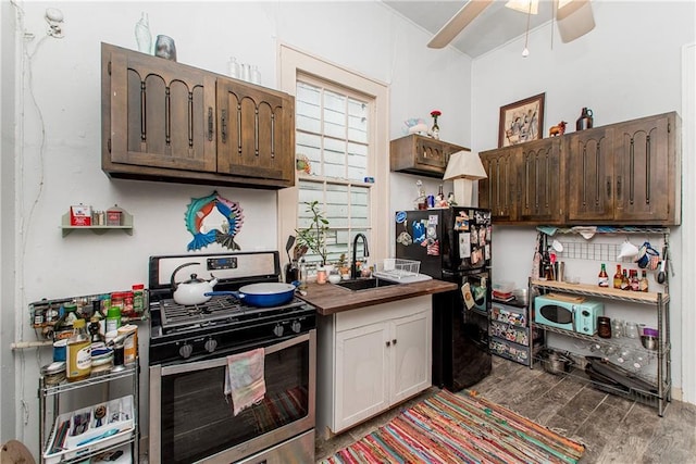 262830 N Rampart St, New Orleans, LA 70117 - kitchen with gas stove, freestanding refrigerator, a sink, wood finished floors, and a ceiling fan