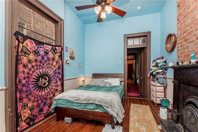 262830 N Rampart St, New Orleans, LA 70117 - bedroom with wainscoting, wood-type flooring, ceiling fan, and a fireplace