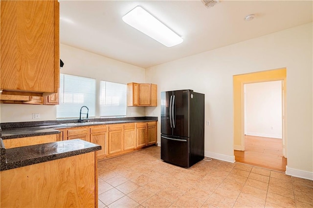 1606 N Broad St, New Orleans, LA 70119 - kitchen with freestanding refrigerator, dark countertops, a sink, and baseboards