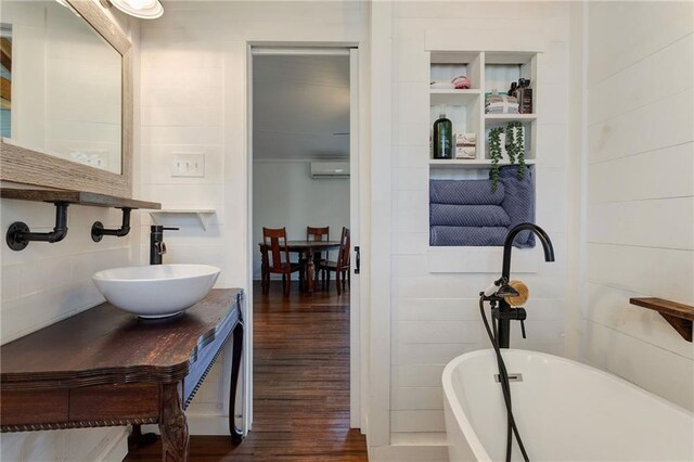 3113 Bayou View Pl, Slidell, LA 70458 - full bath featuring a soaking tub, wood finished floors, an AC wall unit, and vanity