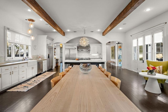1322 S Jahncke Ave, Covington, LA 70434 - dining area with arched walkways, recessed lighting, plenty of natural light, dark wood-type flooring, and beamed ceiling