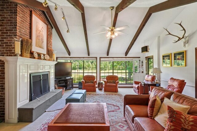 214 Tchefuncte Dr, Covington, LA 70433 - living area featuring beam ceiling, ceiling fan, high vaulted ceiling, a tile fireplace, and track lighting