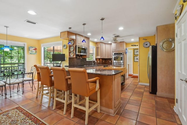 214 Tchefuncte Dr, Covington, LA 70433 - kitchen with stainless steel appliances, backsplash, baseboards, light tile patterned floors, and a breakfast bar