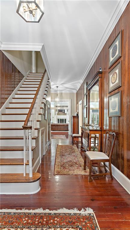 20263 Brunning Rd, Covington, LA 70435 - entrance foyer featuring stairway, hardwood / wood-style floors, baseboards, crown molding, and wood walls