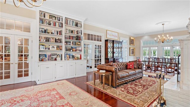 20263 Brunning Rd, Covington, LA 70435 - living room featuring french doors, a chandelier, ornamental molding, and wood finished floors
