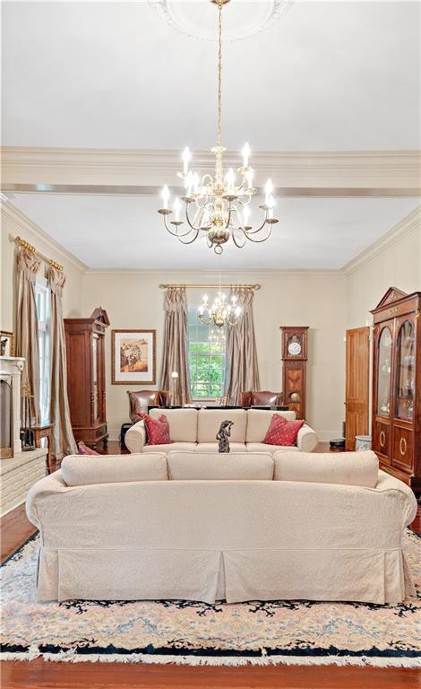 20263 Brunning Rd, Covington, LA 70435 - living area with ornamental molding, a chandelier, and wood finished floors