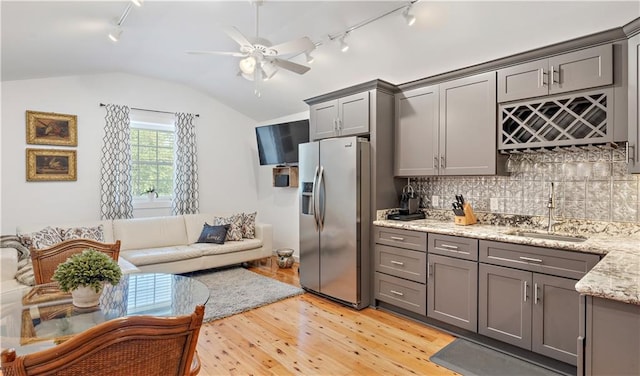 20263 Brunning Rd, Covington, LA 70435 - kitchen with stainless steel fridge with ice dispenser, rail lighting, gray cabinetry, a sink, and vaulted ceiling
