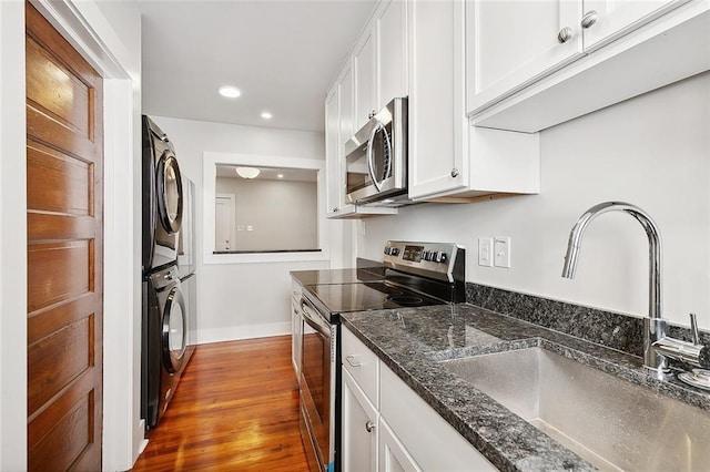 1530 Bordeaux St Unit C, New Orleans, LA 70115 - kitchen featuring stainless steel appliances, estacked washer and dryer, a sink, white cabinetry, and recessed lighting