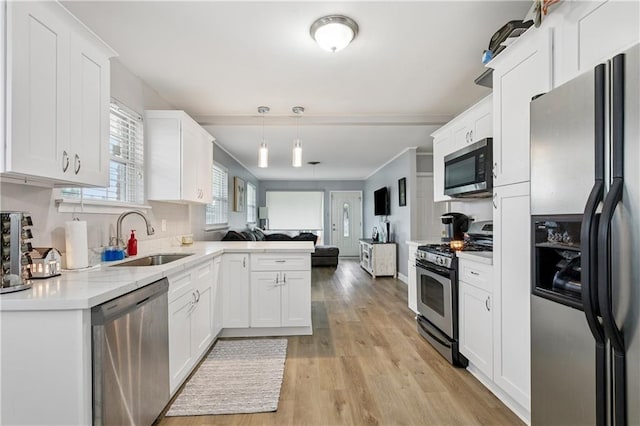 620 Maryland Ave, Metairie, LA 70003 - kitchen with appliances with stainless steel finishes, a sink, open floor plan, a peninsula, and white cabinetry