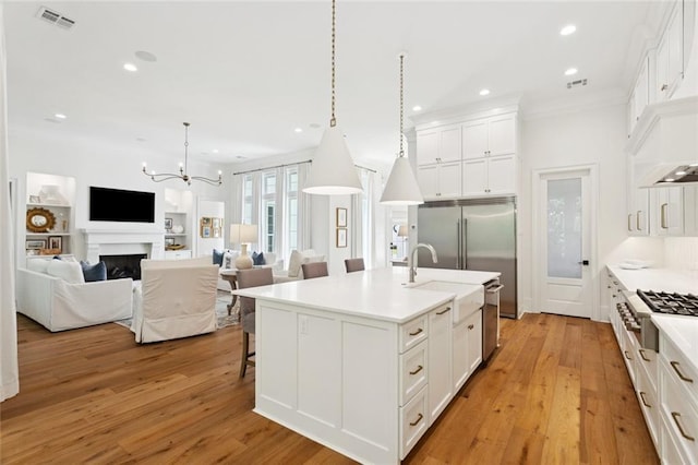 516 N Corniche Du Lac, Covington, LA 70433 - kitchen with stainless steel appliances, light wood-style floors, recessed lighting, white cabinets, and crown molding