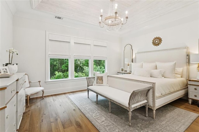 516 N Corniche Du Lac, Covington, LA 70433 - bedroom featuring a chandelier, hardwood / wood-style floors, baseboards, wooden ceiling, and a raised ceiling