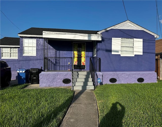 4405 Cartier Ave, New Orleans, LA 70122 - view of front of home with a front yard and stucco siding