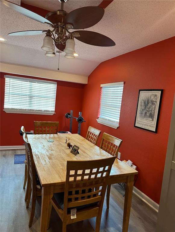 4405 Cartier Ave, New Orleans, LA 70122 - dining area featuring lofted ceiling, ceiling fan, wood finished floors, a textured ceiling, and baseboards