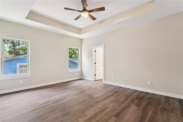 4251 Poplar Dr, Slidell, LA 70461 - unfurnished room with a tray ceiling, plenty of natural light, dark wood-type flooring, and a ceiling fan