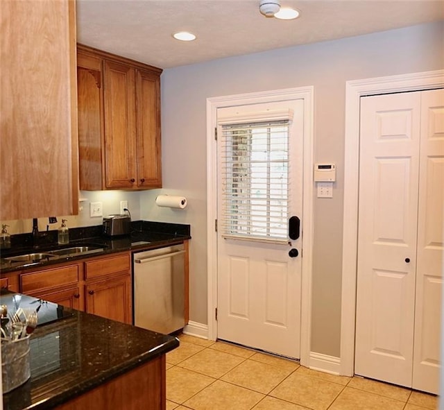 3444 Texas Ave, Kenner, LA 70065 - kitchen with dishwasher, a sink, light tile patterned floors, brown cabinets, and dark stone counters