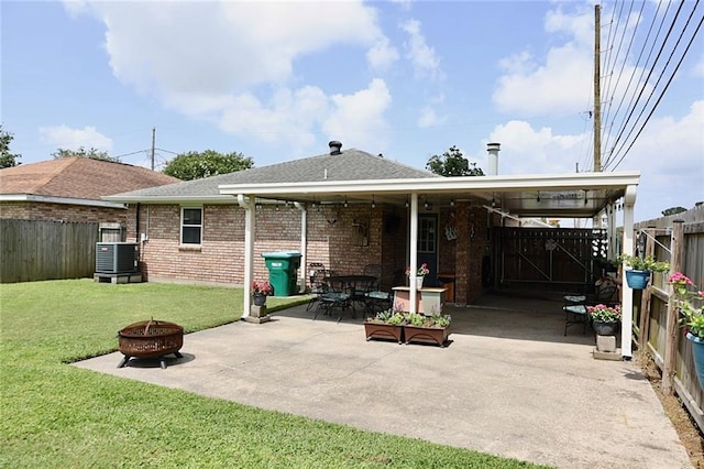 3444 Texas Ave, Kenner, LA 70065 - rear view of house featuring an outdoor fire pit, cooling unit, roof with shingles, a patio area, and brick siding