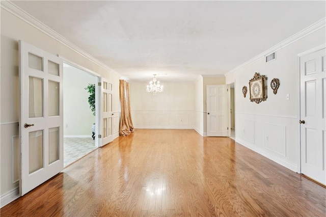 4909 Sunny Pl, Metairie, LA 70006 - empty room with a chandelier, light wood finished floors, ornamental molding, and a decorative wall