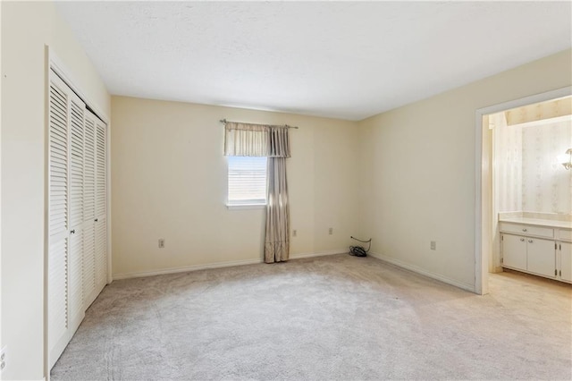 4909 Sunny Pl, Metairie, LA 70006 - unfurnished bedroom featuring light colored carpet, connected bathroom, baseboards, and a closet