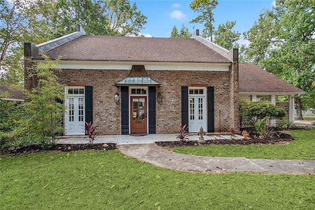 240 Silver Maple Dr, Mandeville, LA 70471 - view of front facade with a front lawn, brick siding, french doors, and roof with shingles
