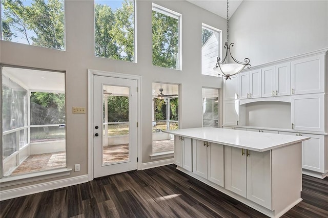 240 Silver Maple Dr, Mandeville, LA 70471 - kitchen with a towering ceiling, white cabinets, light countertops, dark wood finished floors, and hanging light fixtures