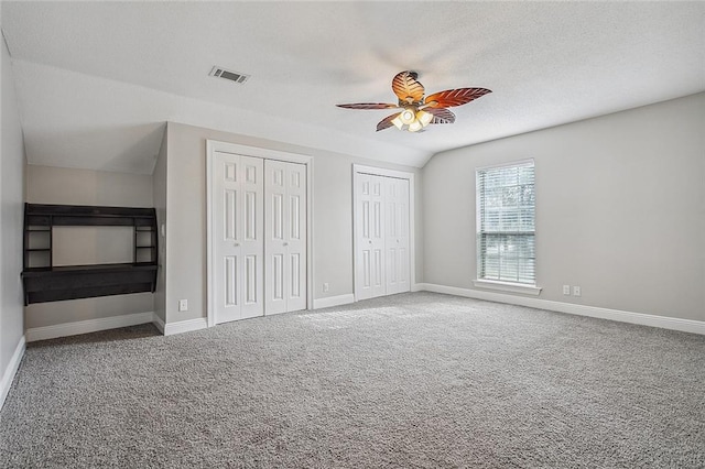 240 Silver Maple Dr, Mandeville, LA 70471 - unfurnished bedroom with two closets, carpet, baseboards, a textured ceiling, and a ceiling fan