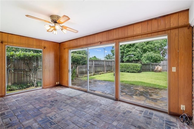 3410 Plymouth Pl, New Orleans, LA 70131 - unfurnished sunroom with ceiling fan, wood walls, brick floors, and baseboards