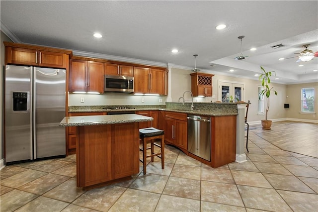3913 Bellview St, Metairie, LA 70002 - kitchen featuring appliances with stainless steel finishes, a kitchen breakfast bar, a peninsula, crown molding, and a center island