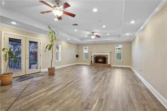 3913 Bellview St, Metairie, LA 70002 - unfurnished living room featuring ceiling fan, wood finished floors, crown molding, french doors, and a tray ceiling