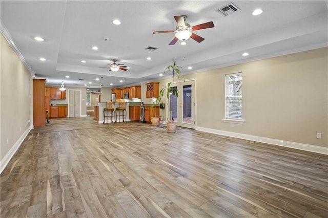 3913 Bellview St, Metairie, LA 70002 - unfurnished living room featuring a raised ceiling, a ceiling fan, recessed lighting, baseboards, and wood finished floors