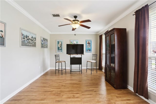 4811 Perelli Dr, New Orleans, LA 70127 - living area featuring crown molding, light wood-style flooring, ceiling fan, baseboards, and healthy amount of natural light