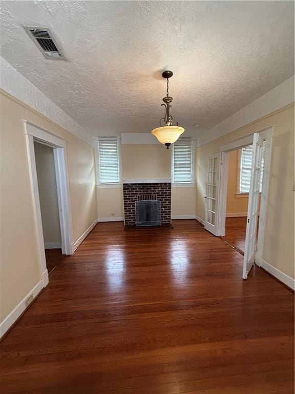 4218 S Liberty St, New Orleans, LA 70115 - unfurnished living room with a textured ceiling, wood finished floors, healthy amount of natural light, and baseboards