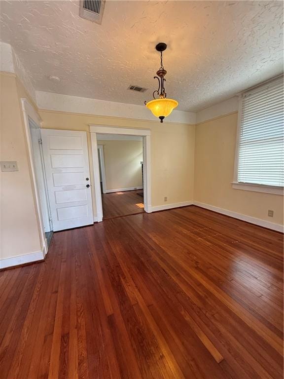 4218 S Liberty St, New Orleans, LA 70115 - unfurnished room with baseboards, a textured ceiling, and dark wood-style flooring