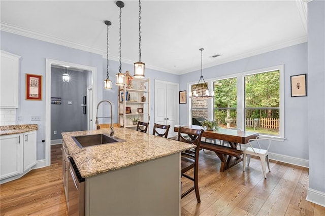 1180 Brook Ct, Mandeville, LA 70448 - kitchen featuring a sink, baseboards, light wood-style flooring, dishwasher, and crown molding