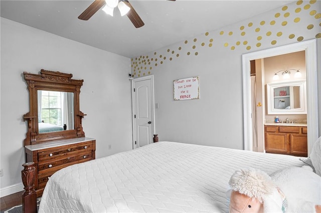 1180 Brook Ct, Mandeville, LA 70448 - bedroom with baseboards, a sink, wallpapered walls, connected bathroom, and ceiling fan
