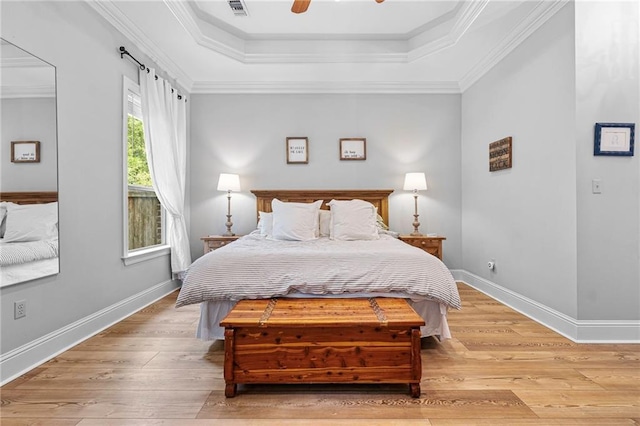 1180 Brook Ct, Mandeville, LA 70448 - bedroom with a tray ceiling, light wood finished floors, baseboards, a ceiling fan, and ornamental molding
