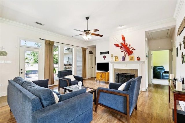 1216 W 23rd Ave, Covington, LA 70433 - living area with attic access, light wood-style flooring, crown molding, a ceiling fan, and a fireplace