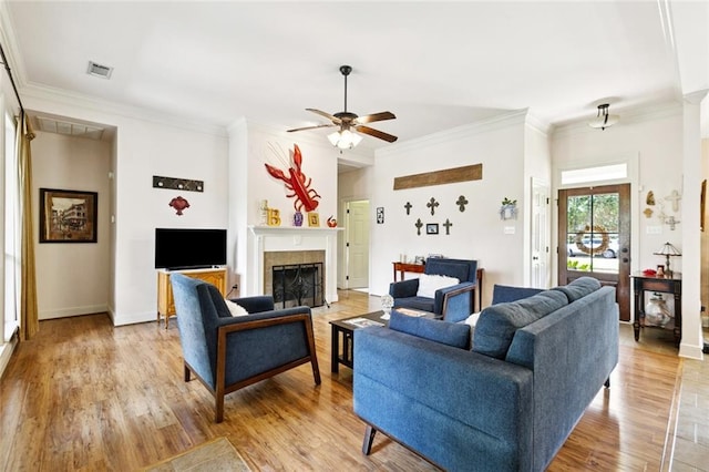 1216 W 23rd Ave, Covington, LA 70433 - living area with a fireplace, a ceiling fan, crown molding, light wood-style flooring, and baseboards