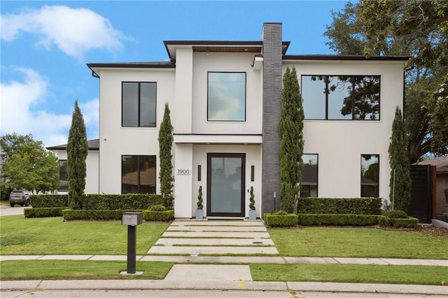 1900 Giuffrias Ave, Metairie, LA 70001 - contemporary house with stucco siding, a front lawn, and a chimney