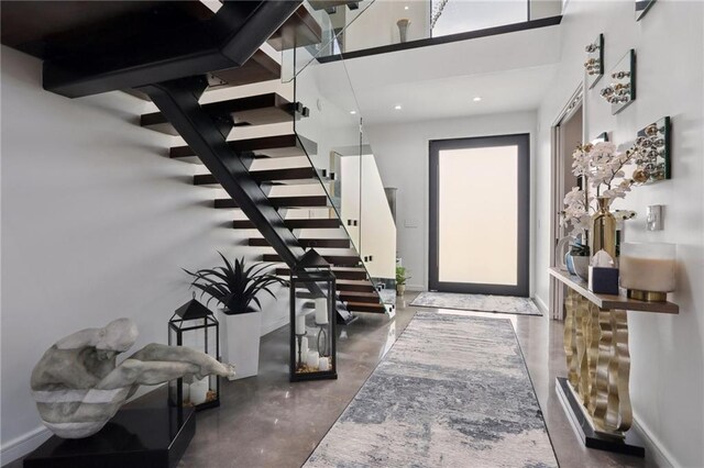 1900 Giuffrias Ave, Metairie, LA 70001 - entryway with finished concrete floors, stairway, a high ceiling, and baseboards