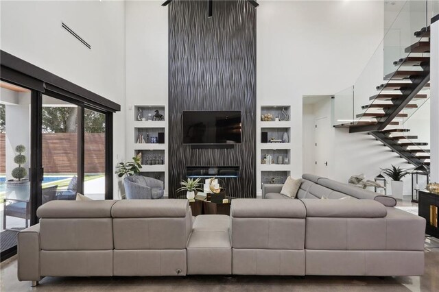 1900 Giuffrias Ave, Metairie, LA 70001 - living area with a high ceiling, built in features, a fireplace, and stairway