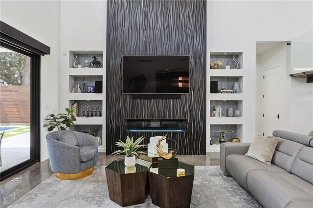 1900 Giuffrias Ave, Metairie, LA 70001 - living area featuring built in features, a towering ceiling, and a fireplace