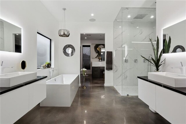 1900 Giuffrias Ave, Metairie, LA 70001 - bathroom featuring concrete flooring, a marble finish shower, two vanities, and a soaking tub
